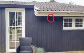 Ein Haus mit dunkelblauer Fassade, einer weißen Tür und einem Fenster.