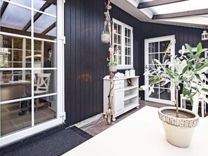 A room with a large window, a white cabinet, and a potted plant. - 4 Star Holiday Home in Blavand (Blavand)