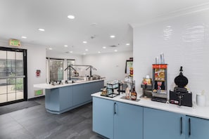A modern cafe with a counter, seating area, and a view of the outdoors.