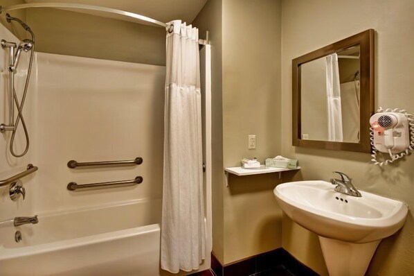Baño con bañera, ducha y lavamanos, equipado con secador de pelo y espejo.