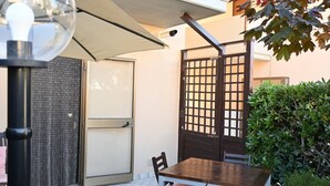 A patio area with a table and chairs, a door, a gate, and a potted plant. - SE273 – Senigallia, studio apartment near the sea (Senigallia)
