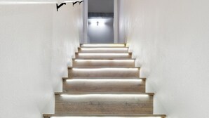 Una escalera con escalones de madera y paredes blancas.