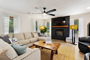 Een woonkamer met een bank, salontafel en een open haard.
