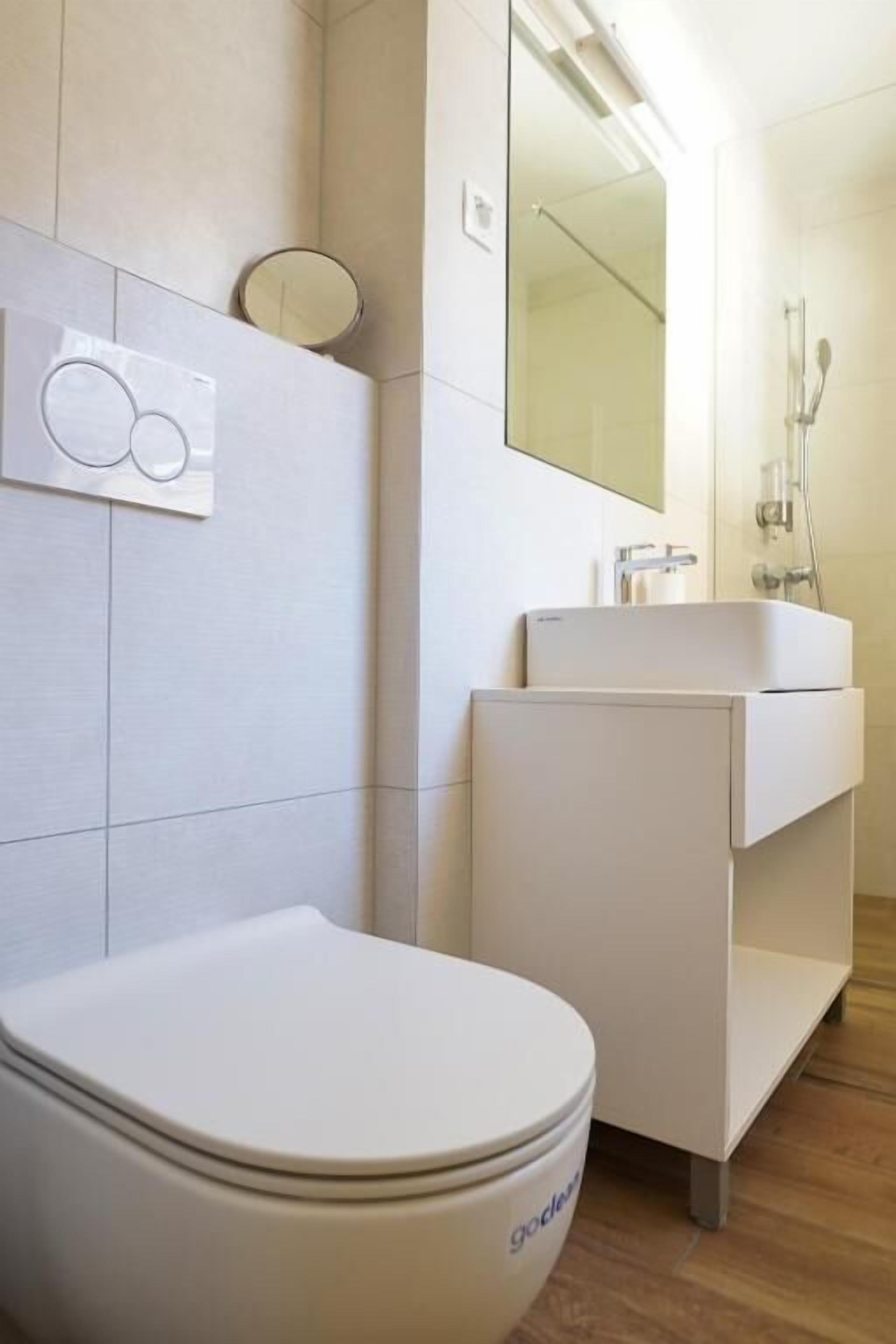 Une salle de bain moderne avec des toilettes, un lavabo et un miroir.