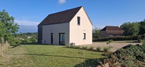 Une maison de plain-pied avec un toit en pente, un petit porche à l’avant et une pelouse bien entretenue.