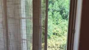 Una habitación con ventana que da a un área boscosa.