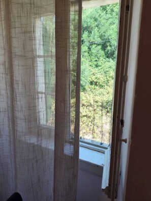 A room with a window overlooking a forested area. - Belvedere di Van D'oro 1886 (Peroulades)