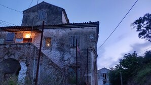 Un edificio rústico de piedra con tejado inclinado, una ventana a la vista y un pequeño balcón.