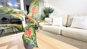 Uma sala de estar com um sofá, uma mesa de centro e um vaso de planta.