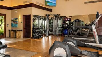 A gym with treadmills, weight machines, and exercise balls.