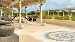 A rooftop terrace with a Buddha statue, two hammocks, and a patterned floor. - COCAY 214, Piscina Estilo Oasis, EcoGym, SkyRoof (Tulum)