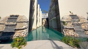 Une piscine aux murs de pierre, sous un ciel dégagé.