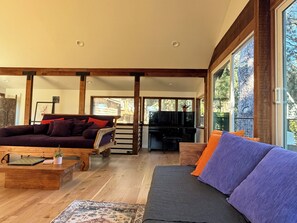 A spacious living room with a sofa, coffee table, and a television.