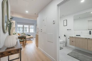Eine moderne Wohnung mit Essbereich, Wohnzimmer und Badezimmer.