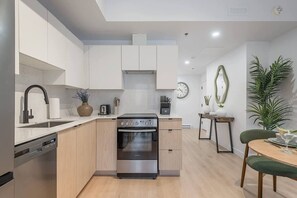 Une cuisine moderne équipée d’un lave-vaisselle, d’une cuisinière et d’un coin repas avec une table et des chaises.
