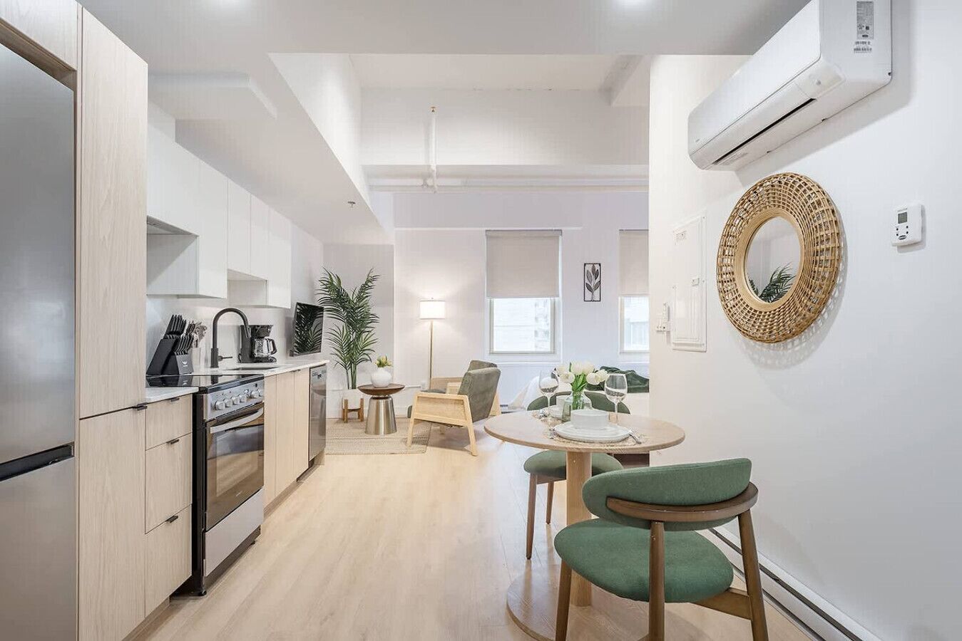 Une cuisine moderne avec un coin repas, une table ronde et un canapé vert.