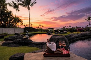 A sunset view with a pool, lounge chairs, and a tray with drinks. - One Ocean Estates Luxury Ocean View 3 BR Sleeps 6 | Car Incl. w/ 6+ Nights | OOE-2A by KBM (Kamuela)