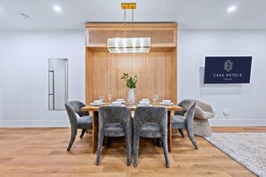 Un comedor moderno con una pared de acento de madera, una planta central y un letrero de 'CASA HOTELS TORONTO'.