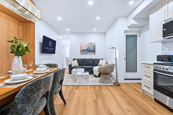 Une chambre d’hôtel moderne comprenant un coin repas, un canapé, une cuisine et un espace de détente.