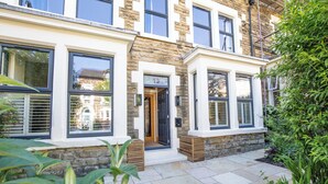 A townhouse with a stone facade, large windows, and a well-maintained garden.