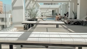 A modern rooftop pool area with lounge chairs, a pool, and potted plants. - Depto. céntrico cerca Movistar Arena (Santiago)