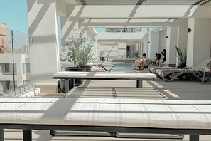 A modern rooftop pool area with lounge chairs, a pool, and potted plants. - Depto. céntrico cerca Movistar Arena (Santiago)