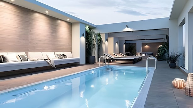 A modern indoor pool area with a lounge area, seating, and a view of the sky. - Depto. céntrico cerca Movistar Arena (Santiago)