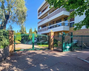 Un immeuble à plusieurs étages, doté d’une entrée sécurisée par un portail, de balcons et d’une enseigne indiquant « FABRON 290 ».