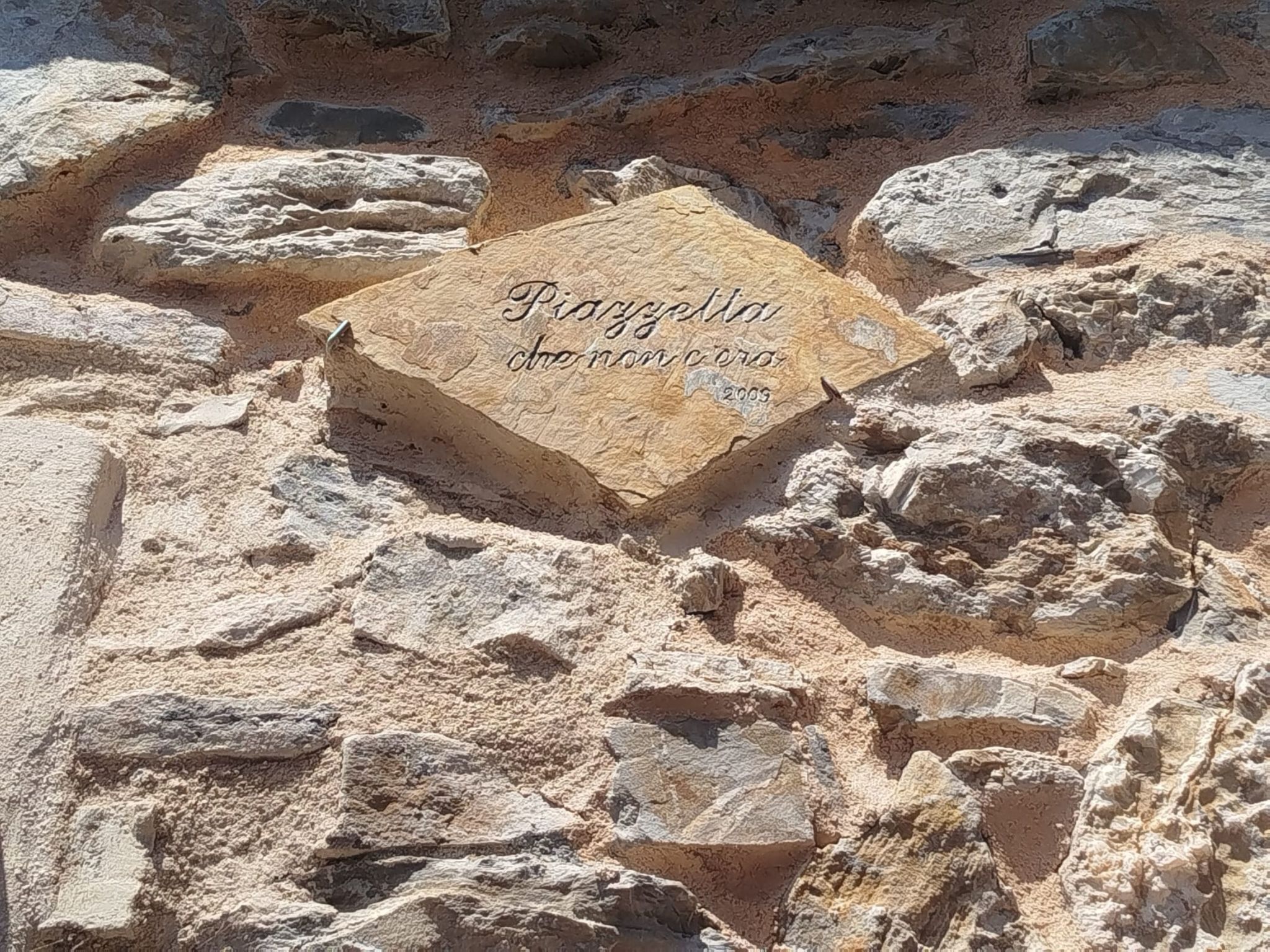 A stone plaque with inscriptions on a rocky surface.