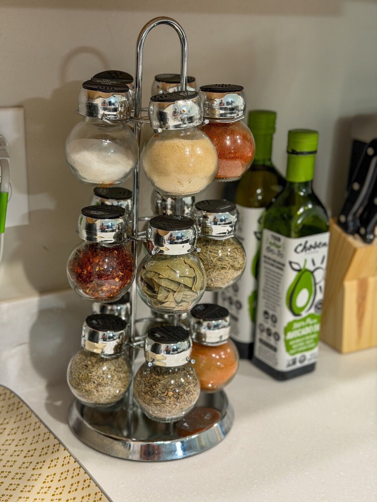 A spice rack with multiple containers on a kitchen counter.