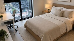 A modern bedroom with a large bed, a desk, and a view of city buildings. - Elegant 1+1bed 1bath |Sauna|Gym | Cold plunge (Toronto)