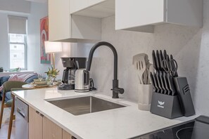 Eine moderne Küche mit doppelter Spüle, einer Kaffeemaschine und einem Messerblock.