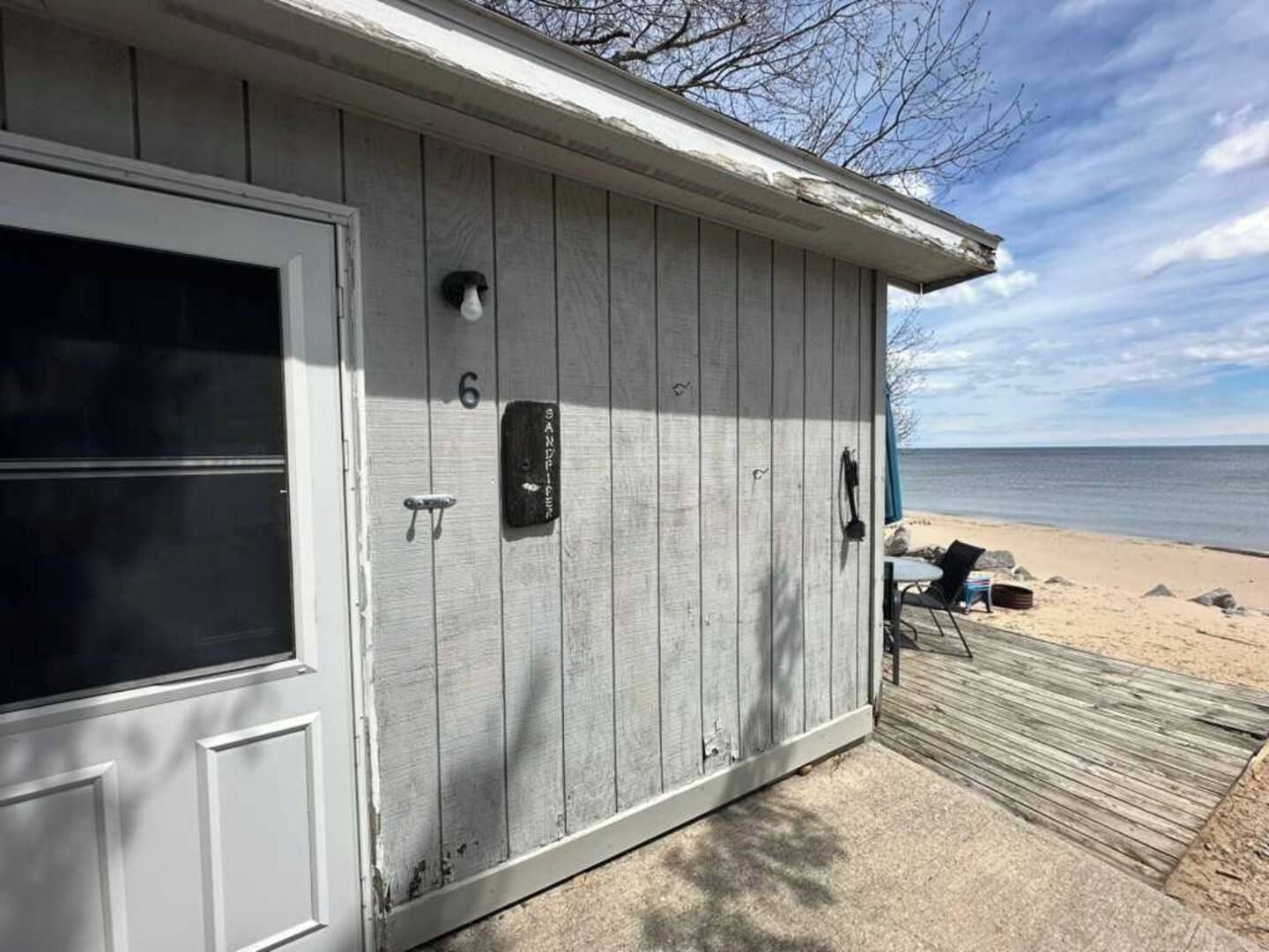 Un bâtiment en bois avec une porte, une boîte aux lettres et le chiffre « 6 » peint sur le mur.