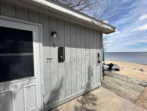 A wooden building with a door, a mailbox, and a number '6' on the wall.