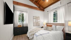A bedroom with a bed, a dresser, a TV, and a window with curtains. - New Cozy 2-bedroom studio in Walnut Creek with AC (walnut creek)