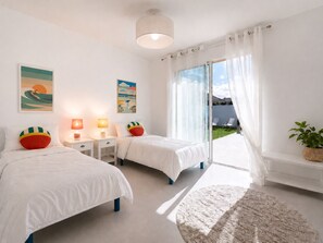 A bedroom with two beds, bedside tables, lamps, and artwork. - Maison Terre Océan (Angles)