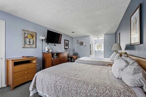 A bedroom with two beds, a desk, a TV, and a chair. - Pet Friendly Studio for 4! Pool and Hot Tub! (Ocean Shores)