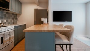 Een moderne keuken met een centraal eiland, een inbouwoven en een magnetron.