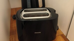 A black Philips toaster on a wooden floor with a white cabinet in the background. - 2 People | Near town center and beaches | Air-conditioned | Garden (Cavalaire sur Mer)