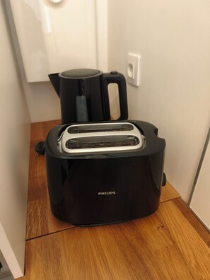 A black Philips toaster on a wooden floor with a white cabinet in the background. - 2 People | Near town center and beaches | Air-conditioned | Garden (Cavalaire sur Mer)