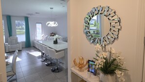 Ein modernes Interieur mit Essbereich, einer Konsole mit Dekoration und einem einzigartigen Spiegel.