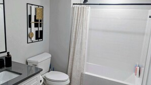 Une salle de bain avec des toilettes, un lavabo et un rideau de douche.