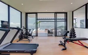 Ein Fitnessstudio mit Laufbändern, einem Ergometer, einer Bank und Gewichten.