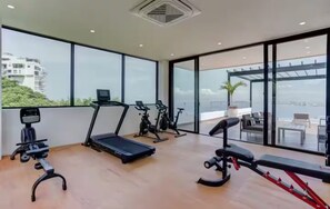 A modern gym with cardio equipment, a treadmill, and a rowing machine. - Tropical luxury (Puerto Vallarta)