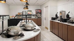 A kitchen with a buffet setup, a coffee machine, and a refrigerator. - Accessible 1BR Suite | Hot Breakfast & Pool Access (San Antonio)