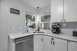 A kitchen with white cabinets, a coffee machine, and a sink. - 3BR Home, Indoor Pool, Hot Tub, Dog Friendly (Gulf Breeze)