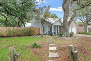 A residential property with a stone pathway leading to the front door, surrounded by a wooden fence and mature trees. - 3BR Home, Indoor Pool, Hot Tub, Dog Friendly (Gulf Breeze)