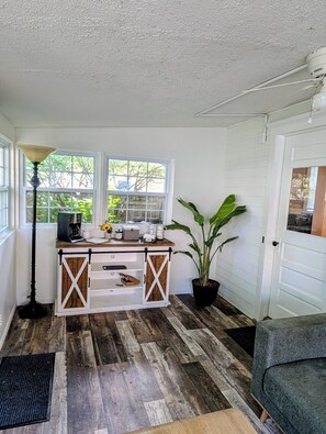 Una cocina con mostrador de madera, una cafetera y una planta en maceta.