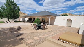 Una casa con patio, mobiliario exterior y vistas del paisaje circundante.