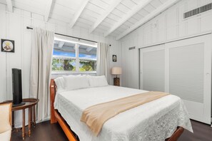 Ein Zimmer mit Bett, Fenster, Fernseher und Kleiderschrank.